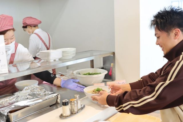 近江牛メニューを受け取る学生