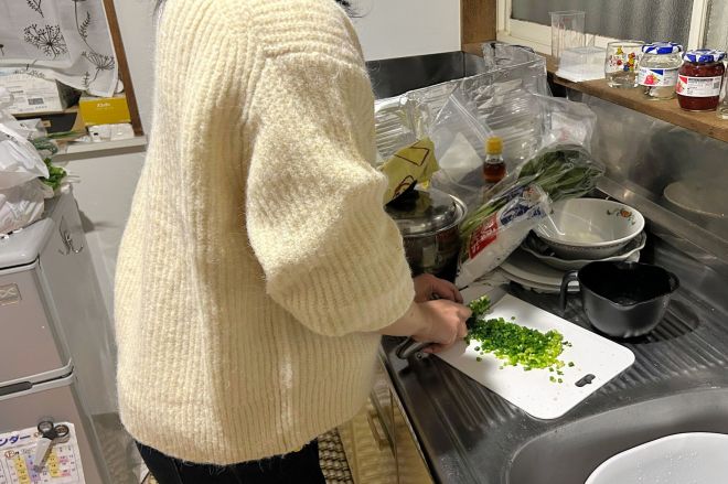 きょうだいで暮らし始め、台所で楽しそうに料理をつくる妹＝関東地方、高橋淳撮影